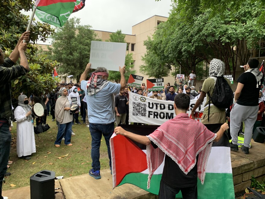 A group of students, some wearing checkered keffiyeh scarves and holding the Palestinian flag, demonstrate on the UT Dallas campus.