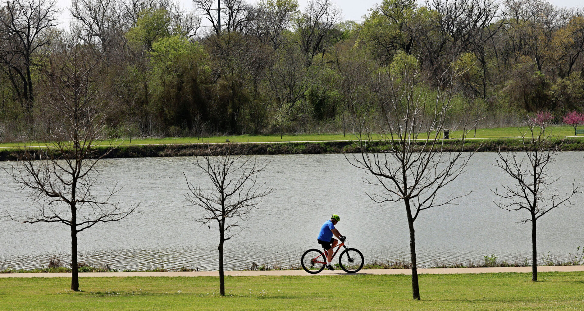 A man rides a bike in Oak Point Park and Nature Preserve, Tuesday, March 25, 2025, in Plano.
