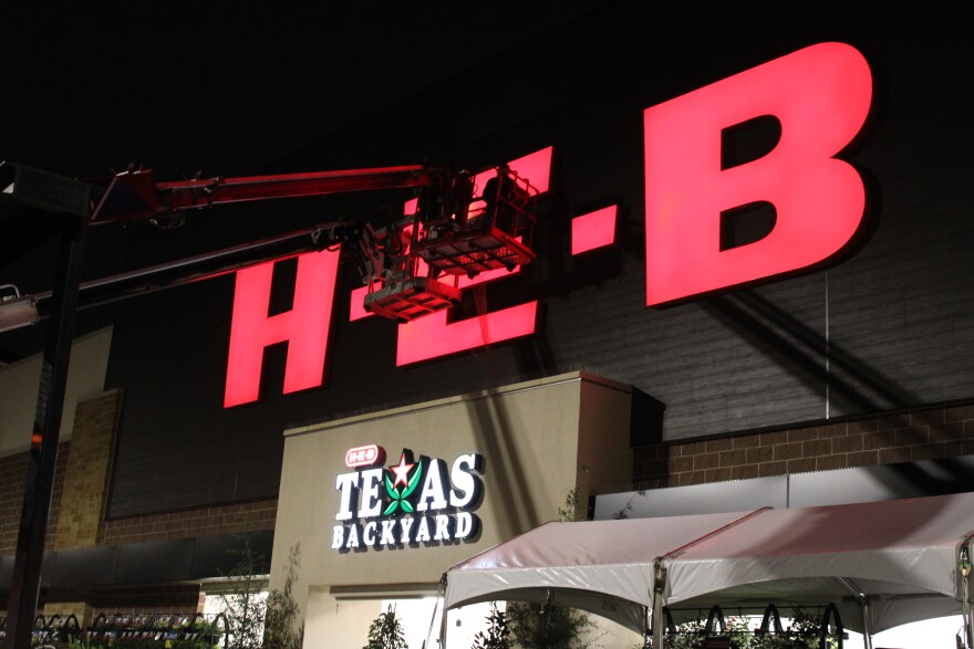 A construction crew put the final touches on the H-E-B sign while customers camped out nearby. May 19, 2026.