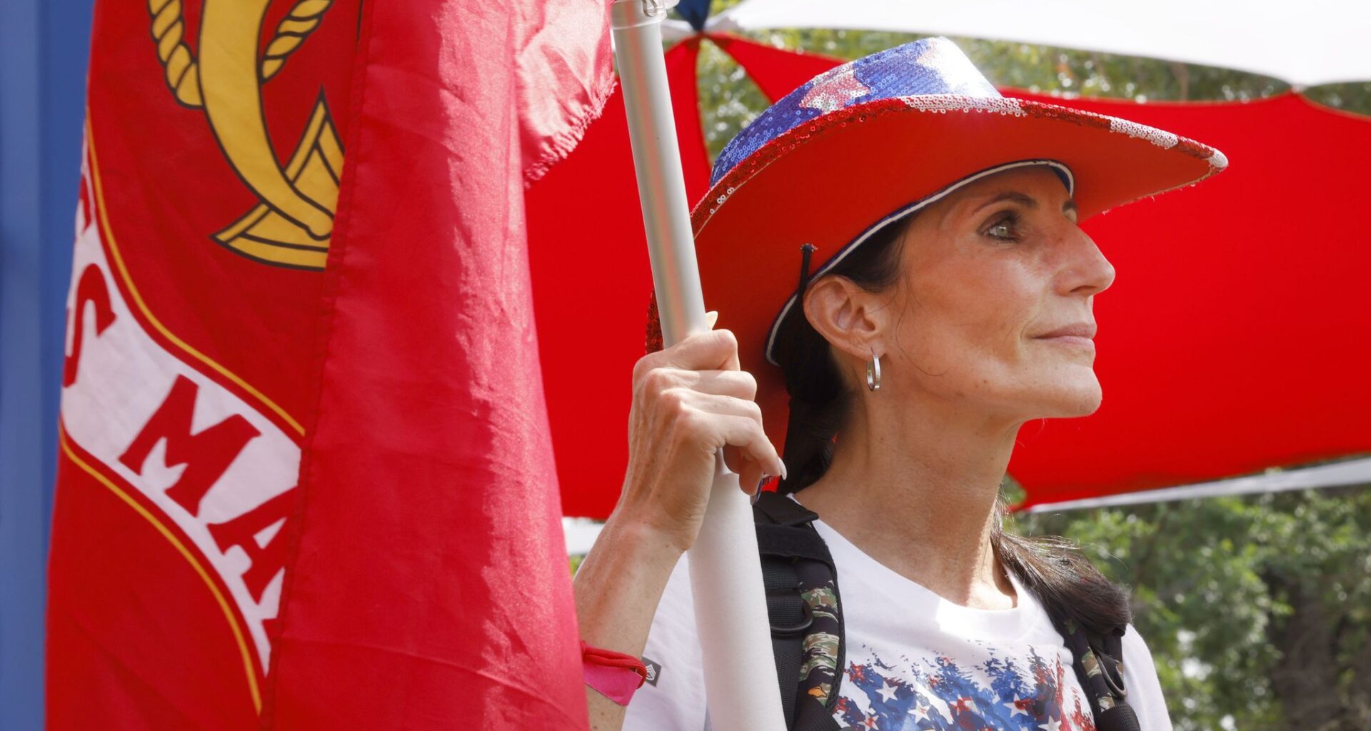 U.S. Marine Corps veteran Selena Warden of Dallas holds a Marine Corps’ flag during the opening ceremony of the Carry The Load, a memorial march to honor, remember and carry the legacy of the nation's heroes, at Reverchon Park, Sunday, May 24, 2026, in Dallas.