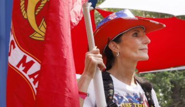 U.S. Marine Corps veteran Selena Warden of Dallas holds a Marine Corps’ flag during the opening ceremony of the Carry The Load, a memorial march to honor, remember and carry the legacy of the nation's heroes, at Reverchon Park, Sunday, May 24, 2026, in Dallas.