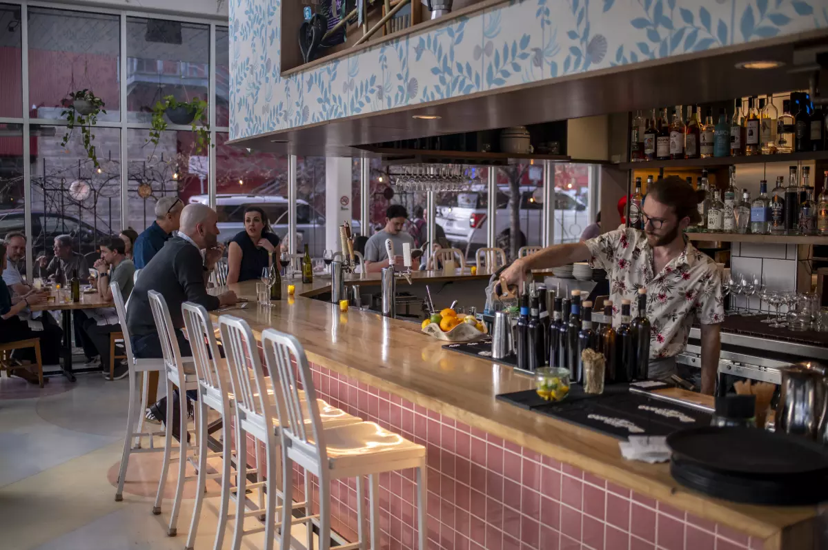 A bartender pours a drink at L'Oca d'Oro, an Italian restaurant in Austin, Texas, that offers a weekly promotion where guests can pay what they want.