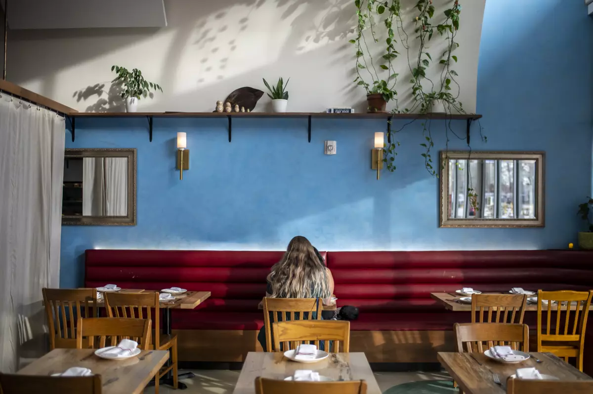 Two guests sit at a table at L'Oca d'Oro. More than a third of Americans are dining out less often than they did last year, according to report from YouGov.