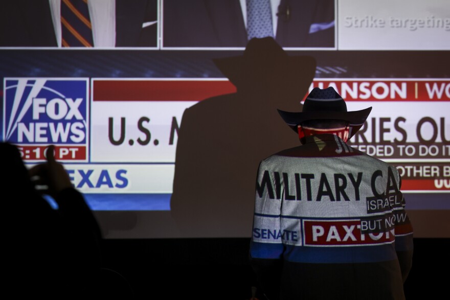 A supporter’s jacket reflects the screen on the runoff election at the Ken Paxton watch party Tuesday, may 26, 2026, in Plano.