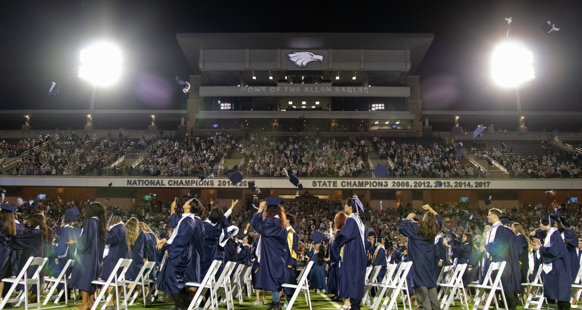 Graduates throw their caps at Allen High School's graduation ceremony on May 23, 2026, at Eagle Stadium in Allen.