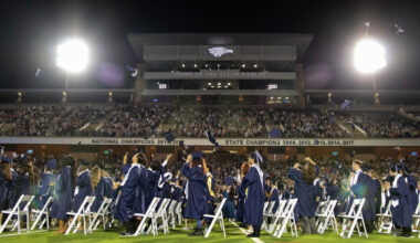 Graduates throw their caps at Allen High School's graduation ceremony on May 23, 2026, at Eagle Stadium in Allen.