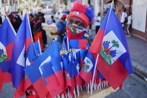 A vendor sells Haitian flags during a National Flag Day parade in Port-au-Prince, Haiti, Monday, May 18, 2026. (AP Photo/Odelyn Joseph)