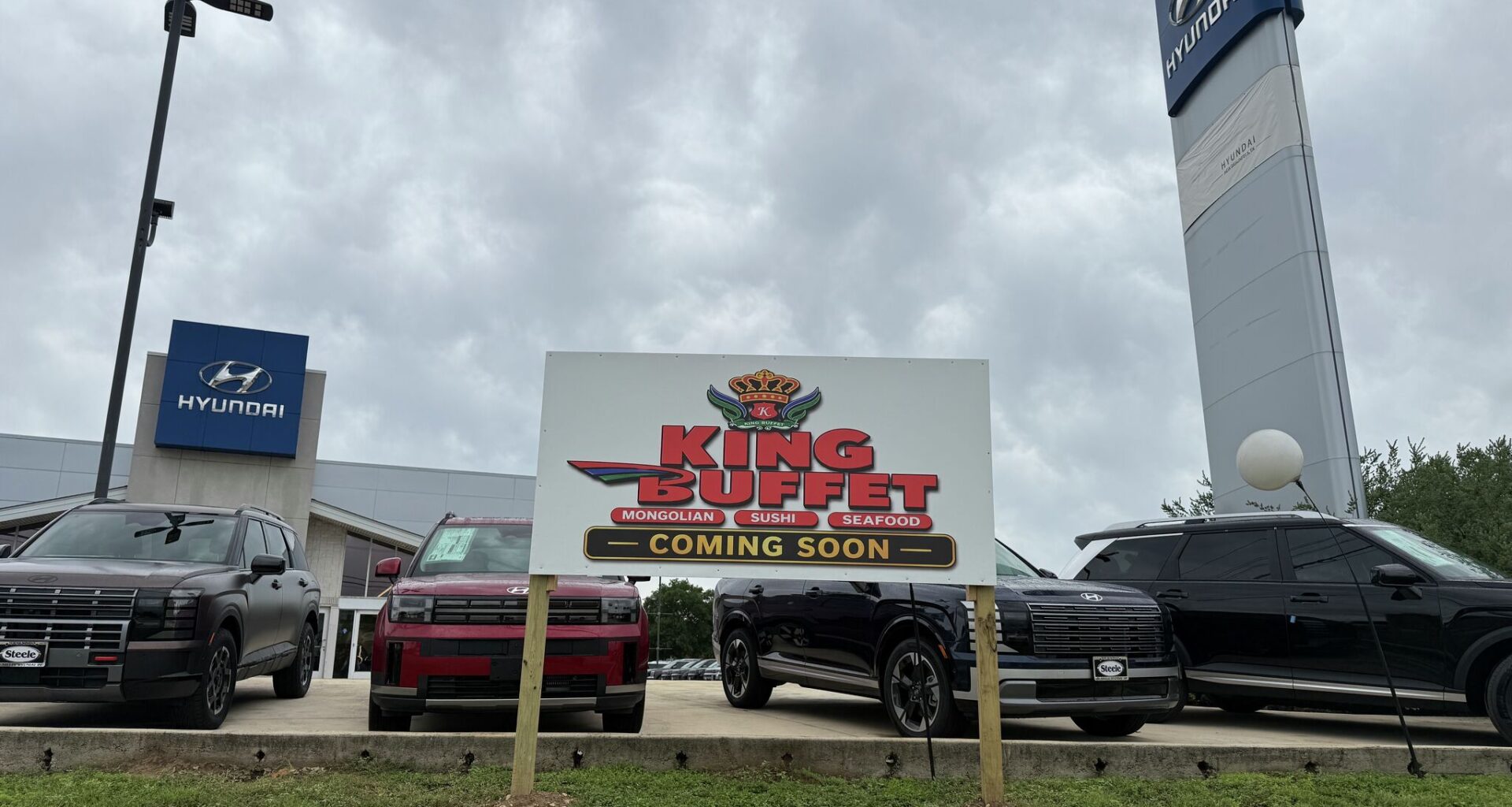 "Coming Soon" signage outside a New Braunfels car dealership along I-35 on May 27, 2026, where state filings and new signage indicate a planned conversion into King Buffet, an all-you-can-eat Asian restaurant concept.