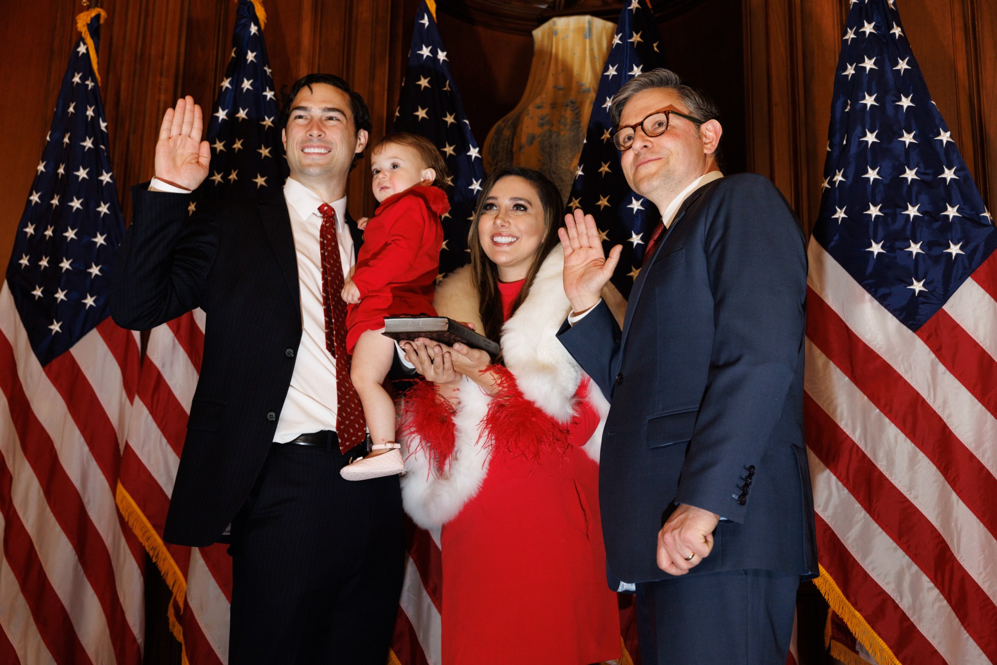 U.S. Rep. Brandon Gill and his family, including wife Danielle D'Souza Gill, pose with Mike Johnson in the Rayburn Room of the Capitol Building in Washington, D.C. during the opening of the 119th Congress. D'Souza Gill is the daughter of right-wing commentator Dinesh D'Souza, who is Indian.