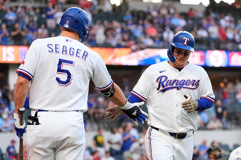 Texas Rangers' Corey Seager (5) and Joc Pederson, right, celebrate Pederson's solo home run in the first inning of a baseball game against the Arizona Diamondbacks Tuesday, May 12, 2026, in Arlington, Texas. (AP Photo/Tony Gutierrez)