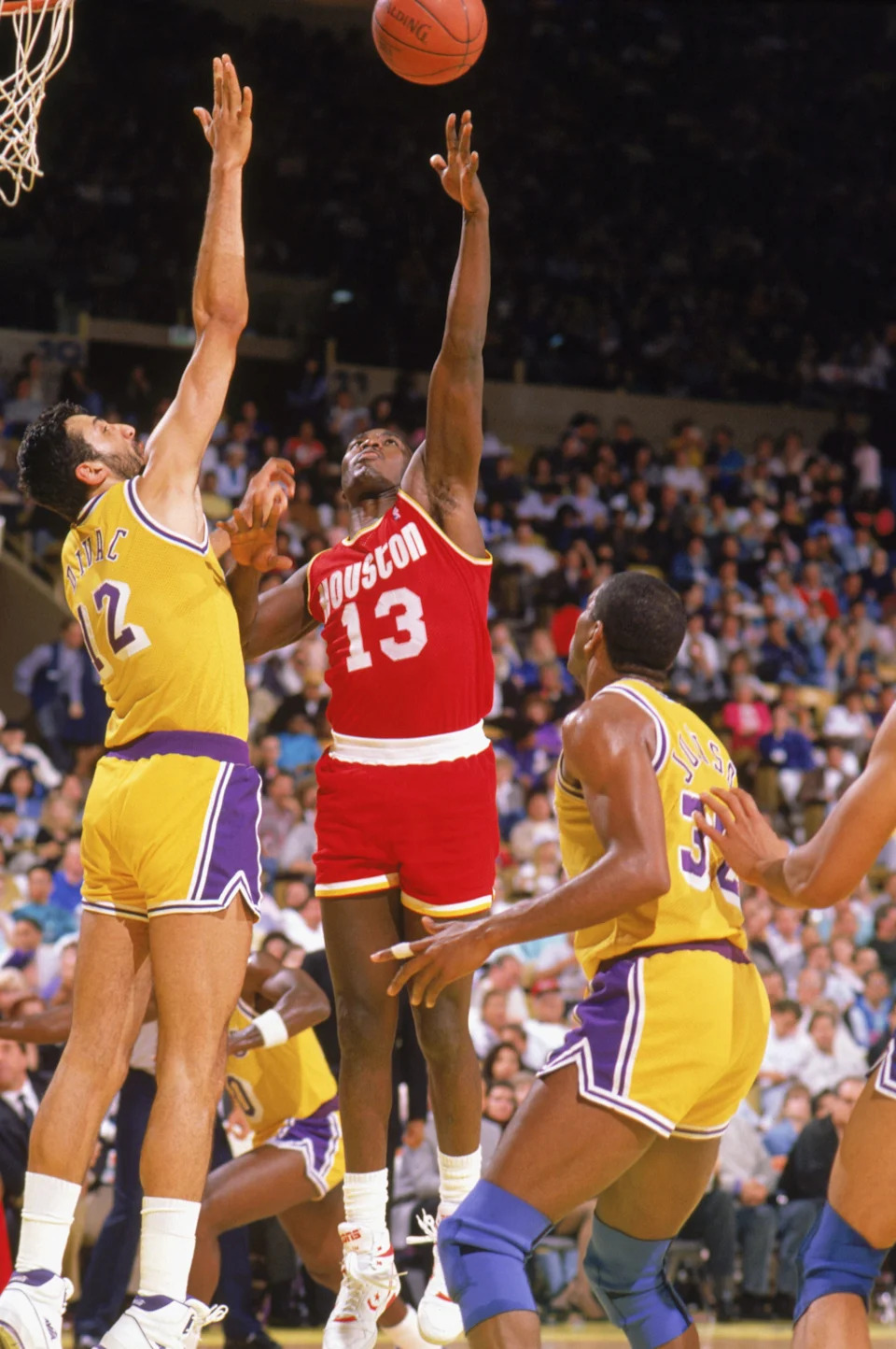 INGLEWOOD -1989: Larry Smith #13 of the Houston Rockets makes a hook shot over Vlade Divac #12 of the Los Angeles Lakers during a game in the1989-90 season at the Forum in Inglewood, California. NOTE TO USER: User expressly acknowledges and agrees that, by downloading and/or using this Photograph, User is consenting to the terms and conditions of the Getty Images License Agreement. (Photo by: Ken Levine/Getty Images)