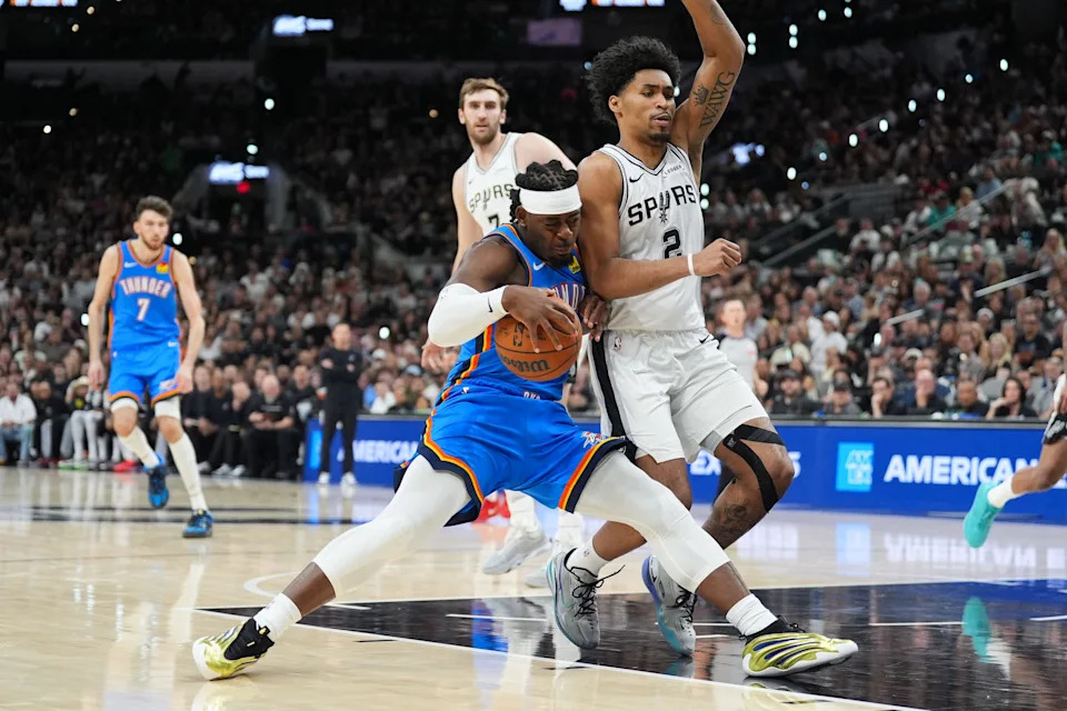 May 24, 2026; San Antonio, Texas, USA; Oklahoma City Thunder forward Luguentz Dort (5) drives the ball while defended by San Antonio Spurs guard Dylan Harper (2) in the fourth quarter during game four of the western conference finals for the 2026 NBA playoffs at Frost Bank Center. Mandatory Credit: Daniel Dunn-Imagn Images