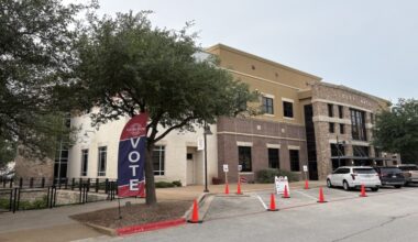 Outside Bee Cave City Hall with "vote" flag.