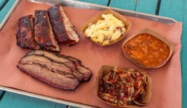 Plate of barbecue with brisket, ribs and three sides.