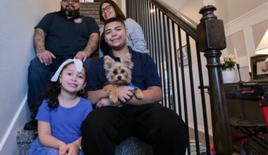 U.S. Marine veteran Luis Valdez sits on the staircase at his family's new home with his wife, two children and the family dog, Charlie. (Courtesy Homes4WoundedHeroes)