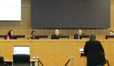 HISD board of managers sitting and listening to a speaker