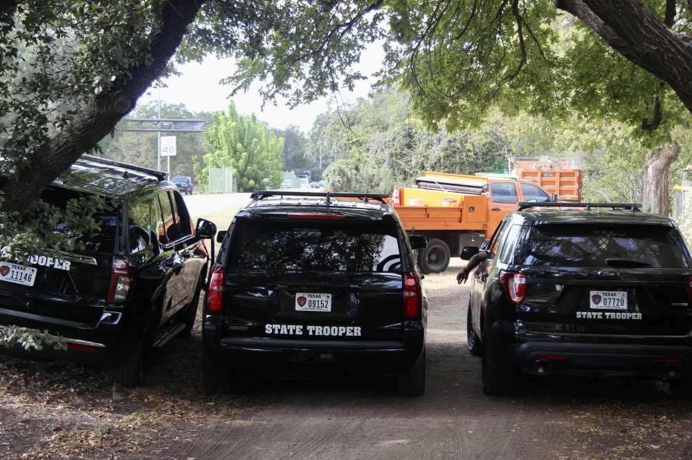 Three Texas Department of Public Safety vehicles parked near trees in Austin.