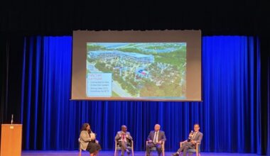 people sitting on a stage for a panel discussion