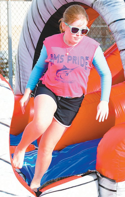 Brundrett Middle School sixth grader Chloe Broyles runs out of an inflatable obstacle course on Field Day.