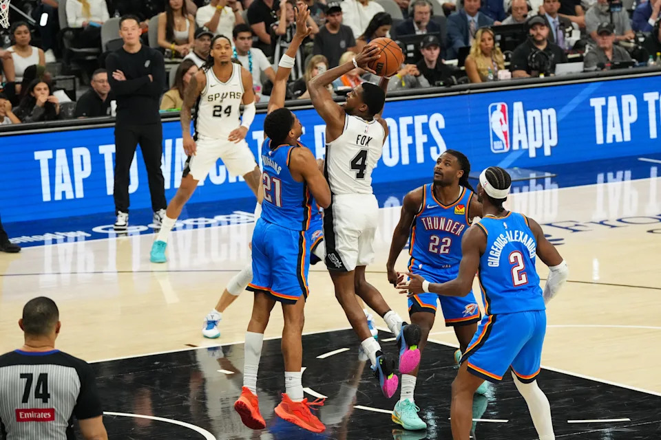 May 24, 2026; San Antonio, Texas, USA; San Antonio Spurs guard De'Aaron Fox (4) shoots while defended by Oklahoma City Thunder guard Aaron Wiggins (21) in the third quarter during game four of the western conference finals for the 2026 NBA playoffs at Frost Bank Center. Mandatory Credit: Scott Wachter-Imagn Images