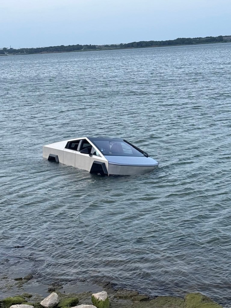 A Tesla Cybertruck partially submerged in water, floating like a boat.