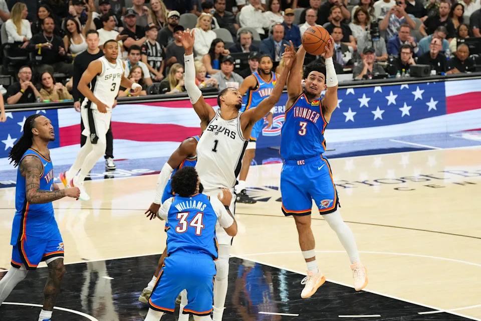 May 24, 2026; San Antonio, Texas, USA; San Antonio Spurs center Victor Wembanyama (1) and Oklahoma City Thunder guard Jared McCain (3) battle for a loose ball in the fourth quarter during game four of the western conference finals for the 2026 NBA playoffs at Frost Bank Center. Mandatory Credit: Scott Wachter-Imagn Images