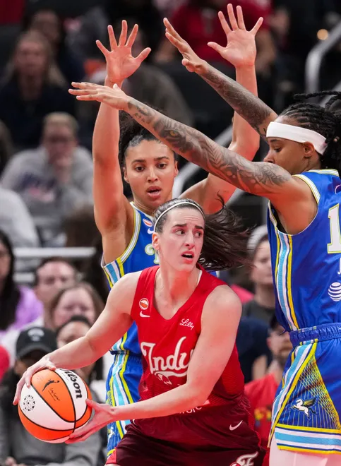 Indiana Fever guard Caitlin Clark (22) looks to pass around Dallas Wings guard Azzi Fudd (35) and Dallas Wings guard Aziaha James (10) on Saturday, May 9, 2026, during the first half of the Fever's season opener game at Gainbridge Fieldhouse in Indianapolis.