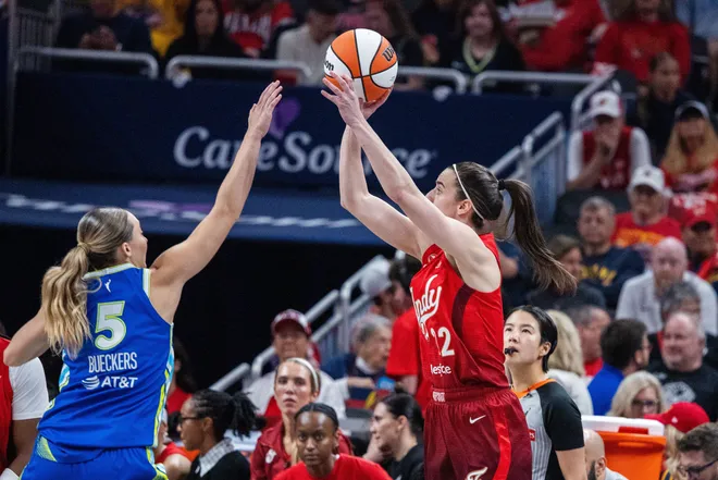 May 9, 2026; Indianapolis, Indiana, USA; Indiana Fever guard Caitlin Clark (22) shoots the ball while Dallas Wings guard Paige Bueckers (5) defends in the second half at Gainbridge Fieldhouse. Mandatory Credit: Trevor Ruszkowski-Imagn Images