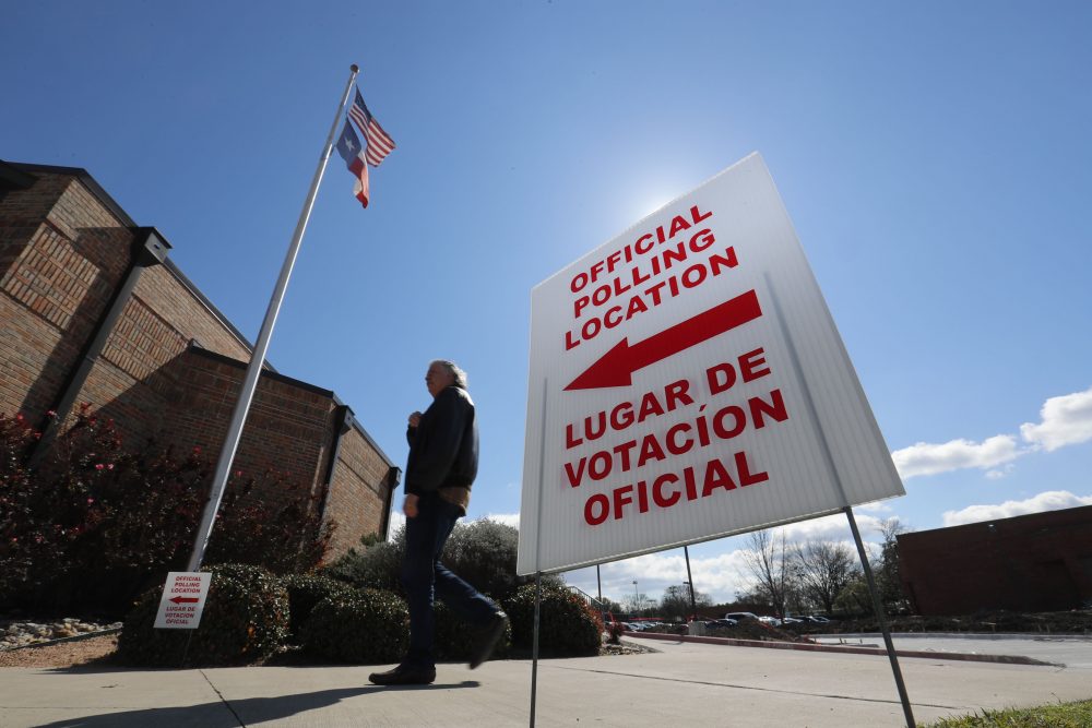 Using both the English and Spanish language, a sign points potential voters to an official polling location during early voting in Dallas.