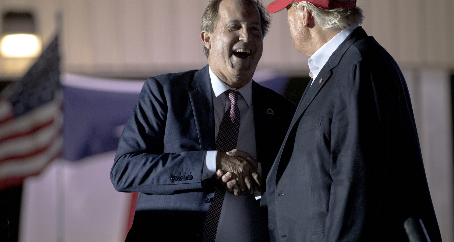 Former President Donald Trump, right, shakes hands with Texas Attorney General Ken Paxton at a rally, Saturday, Oct. 22, 2022, in Robstown, Texas.
