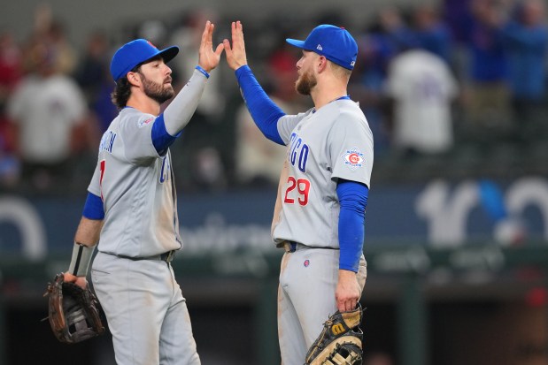 Shortstop Dansby Swanson, left, and first baseman Michael Busch high-five after the Cubs' 7-1 win over the Rangers on Friday, May 8, 2026, in Arlington, Texas. (Julio Cortez/AP)