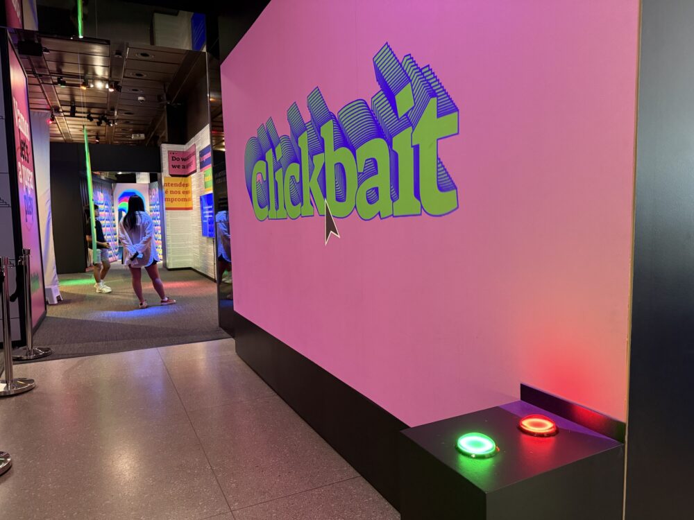 A green and a red button sit in front of a sign that says "Clickbait"