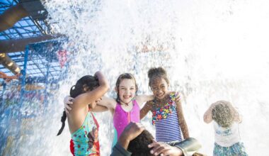 Kids playing and laughing under water spray at DFW water park.