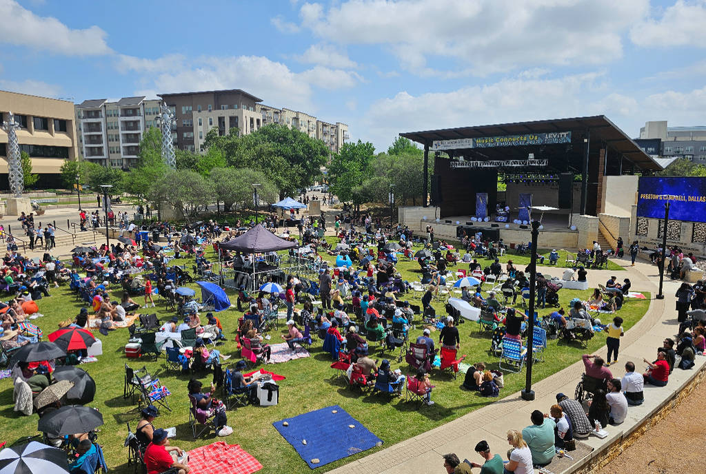Image shows the Levitt Pavilion in Arlington with a crowd of people on a sunny day. 