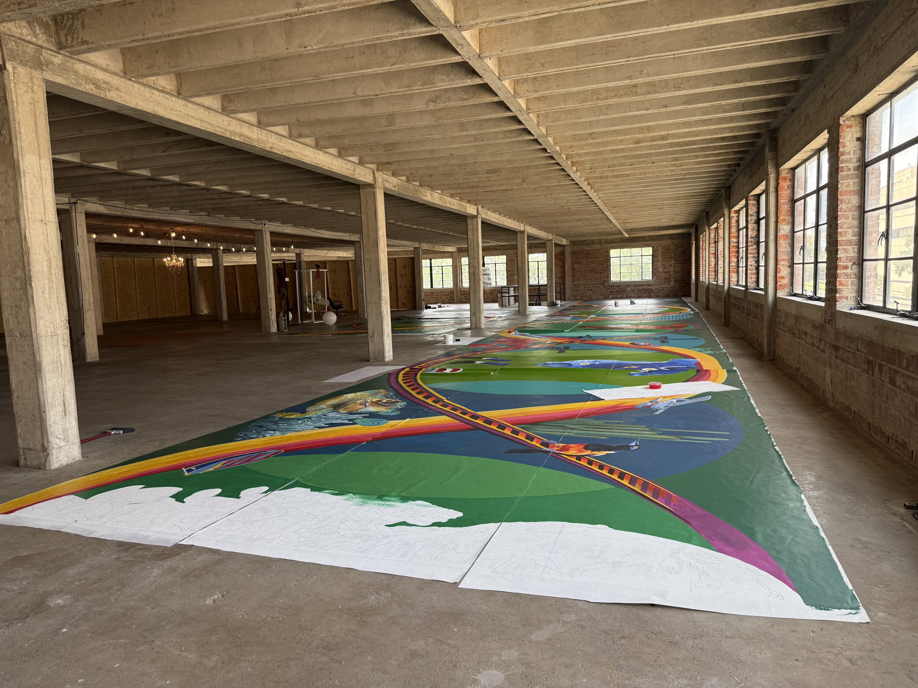 A large painting spread across a studio floor