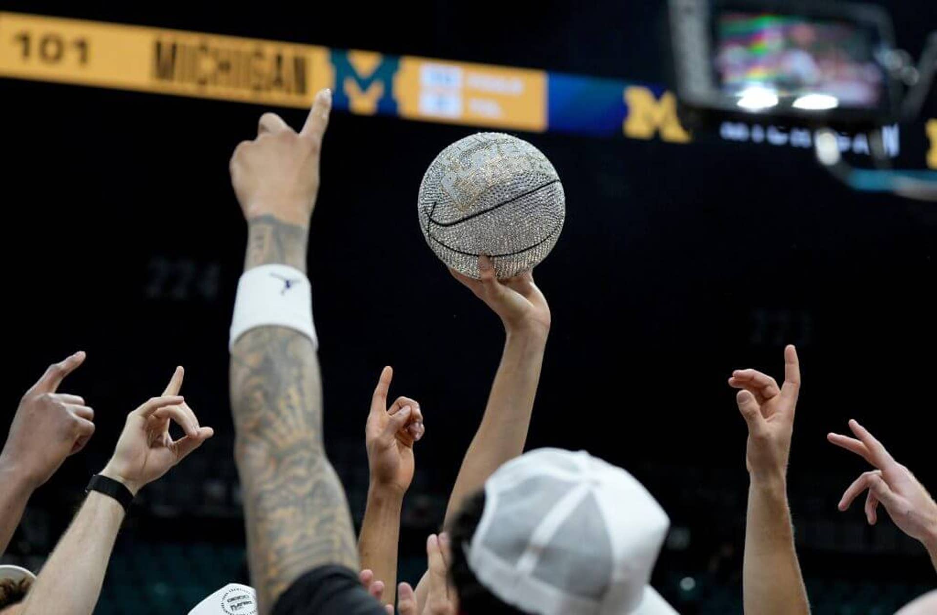 Michigan Wolverines players hold up the silver basketball trophy after winning the 2025 Players Era Championship Game.