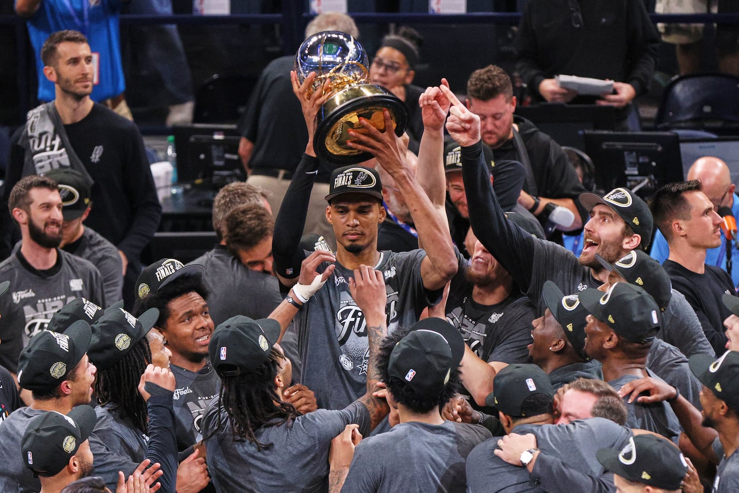 Spurs superstar Victor Wembanyama holds the Oscar Robertson Trophy aloft after San Antonio shocked the Thunder in Game 7 Saturday night in Oklahoma City.