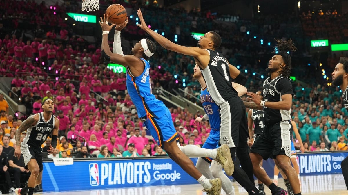 Shai Gilgeous-Alexander shooting basketball over Victor Wembanyama during game