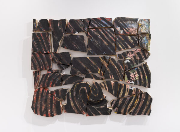 A photograph of a stoneware artwork featuring pieces of clay with the image of a fingerprint on them.