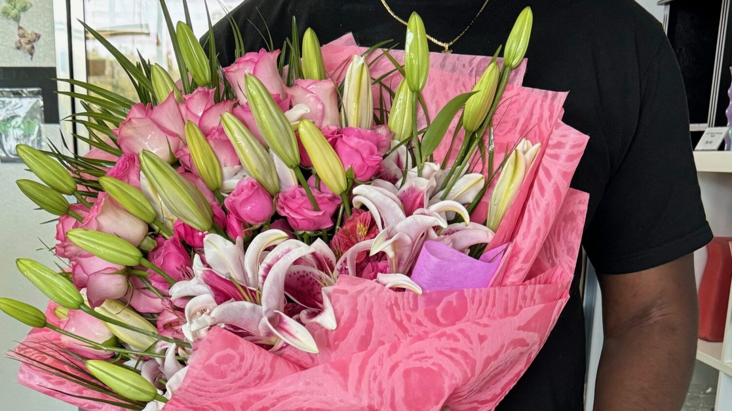 Someone holds a bouquet of pink flowers
