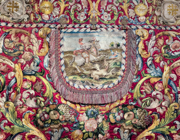 An intricate vestment featuring a knight on horseback slaying a dragon.
