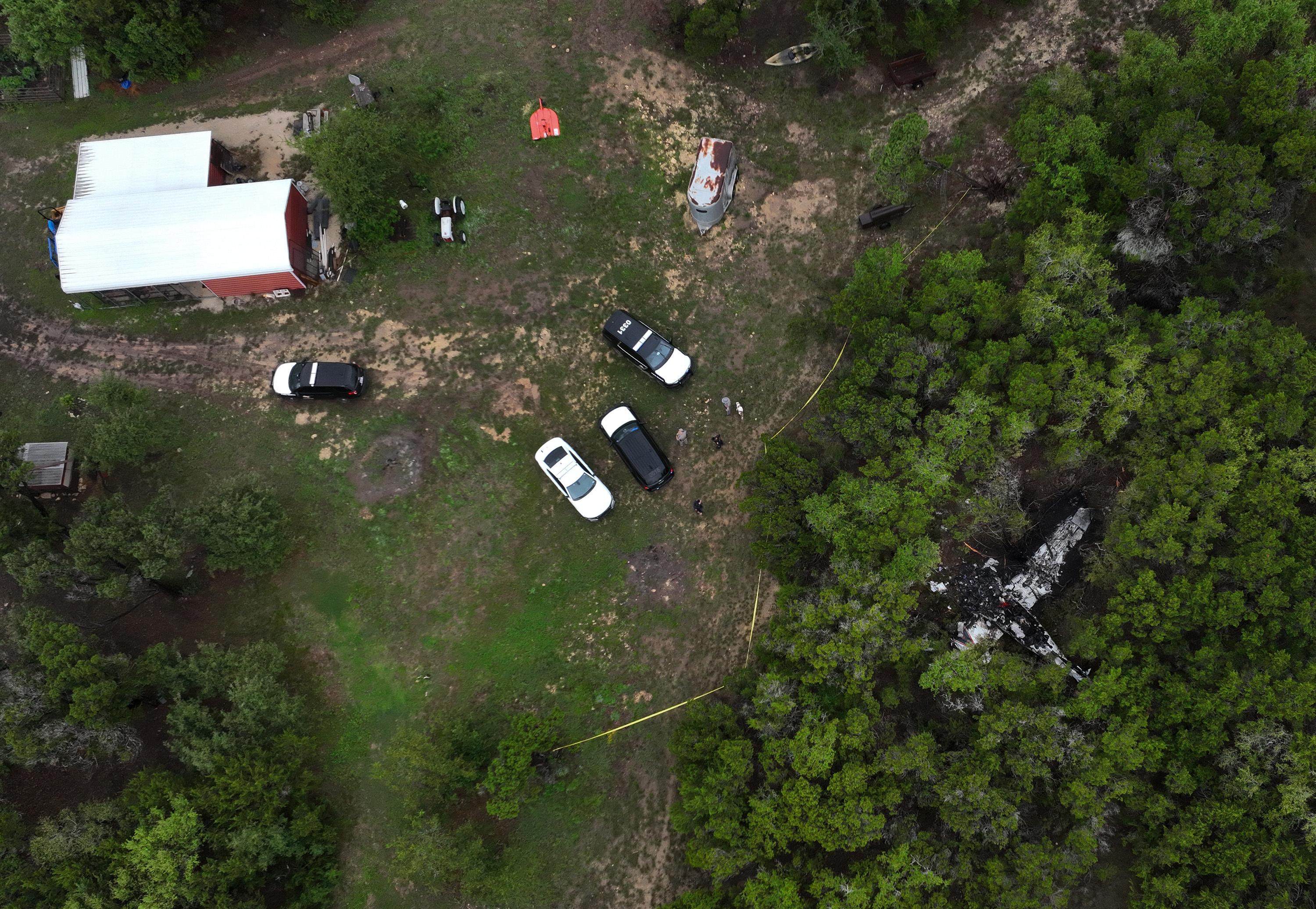 A crashed Cessna airplane is seen in a wooded area in Wimberley, Texas.