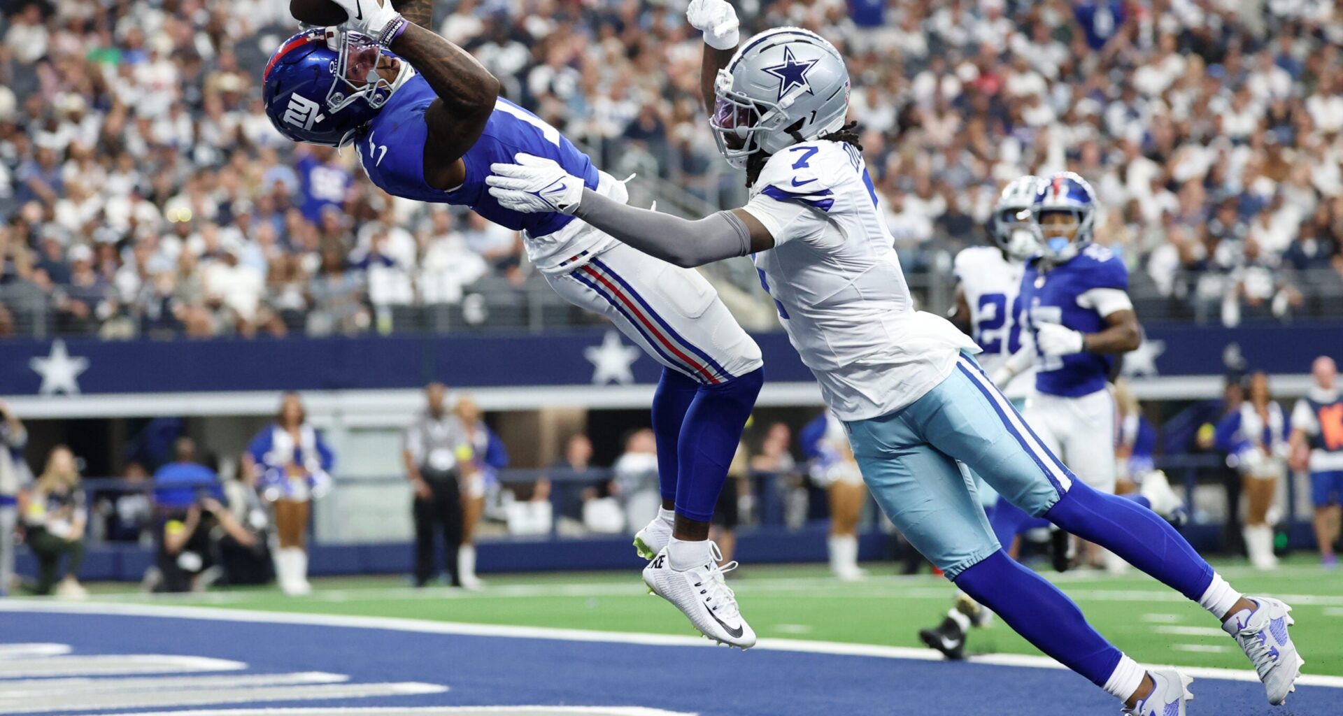 Sep 14, 2025; Arlington, Texas, USA; New York Giants wide receiver Malik Nabers (1) makes a catch for a touchdown against Dallas Cowboys cornerback Trevon Diggs (7) during the second quarter at AT&T Stadium.