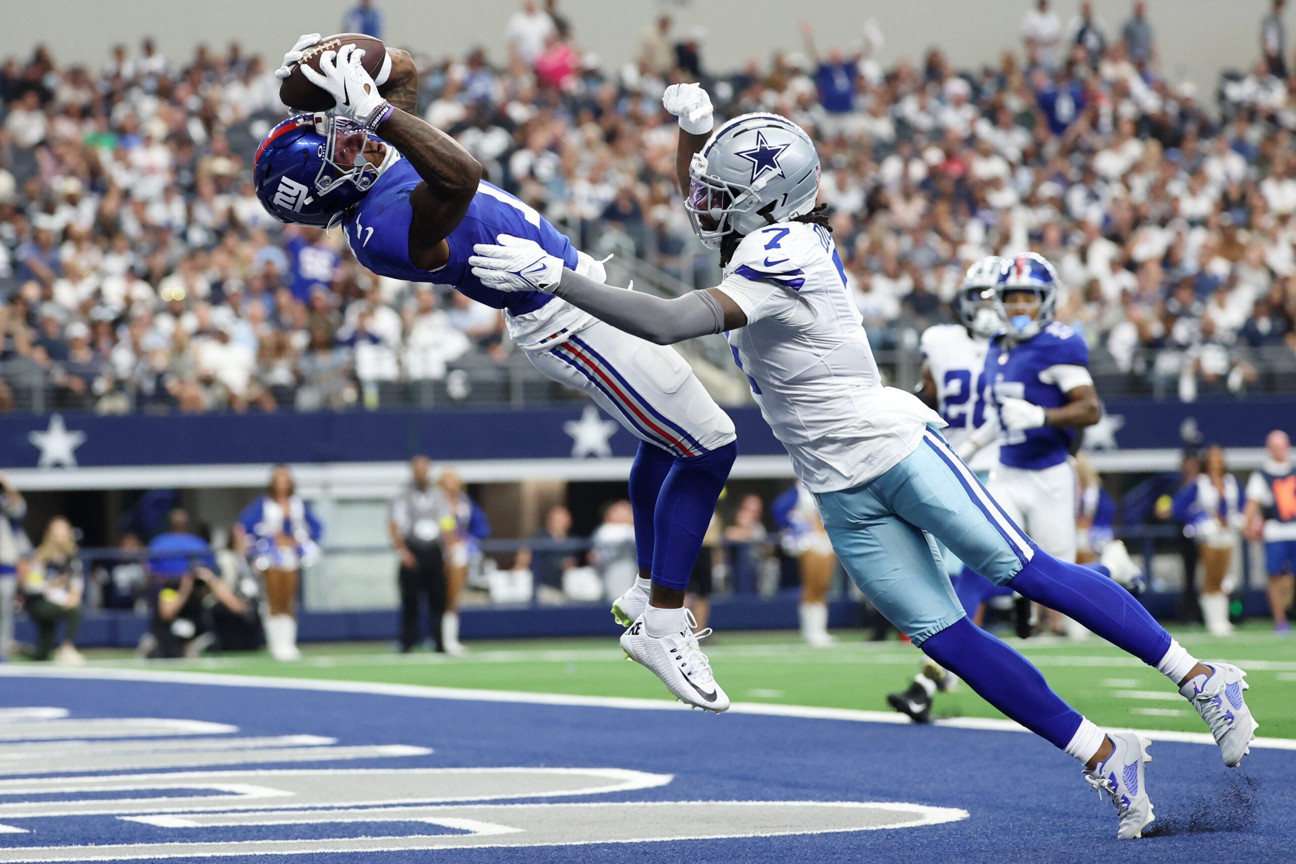 Sep 14, 2025; Arlington, Texas, USA; New York Giants wide receiver Malik Nabers (1) makes a catch for a touchdown against Dallas Cowboys cornerback Trevon Diggs (7) during the second quarter at AT&T Stadium.