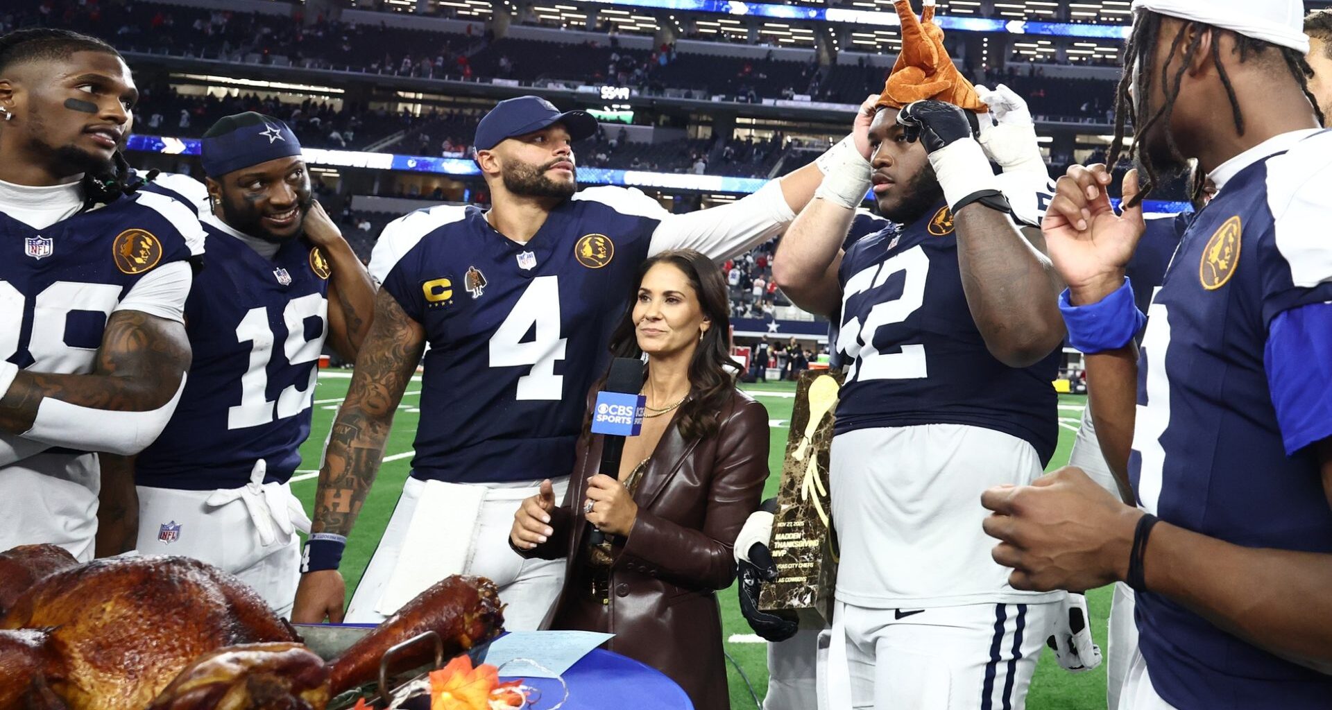 Nov 27, 2025; Arlington, Texas, USA; Dallas Cowboys quarterback Dak Prescott (4) and Dallas Cowboys guard Tyler Booker (52) celebrate with a turkey after the game against the Kansas City Chiefs at AT&T Stadium.