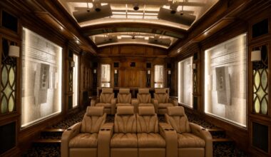 Wide view of luxury private cinema seating in a subterranean home theater in Dallas Texas, with transparent acoustic baffles revealing in-ceiling JBL Synthesis speaker installations as part of a 28-driver Dolby Atmos system designed and integrated by Elliston Systems & Design