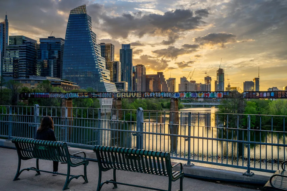 AUSTIN, TEXAS - MARCH 19: A person watches the sunrise over the downtown skyline on March 19, 2024 in Austin, Texas. From peaking in 2022, home prices and apartment rents in Austin, Texas, have declined more than any other city in the country in 2024. While Austin remains ranked as the 10th-largest city in the U.S., the city is now leading a national property cool-down. From 2020 through 2022, Austin led at the forefront of rapid economic growth, with major companies such as Tesla and Oracle arriving. Austin’s recent downswing indicates that various migration patterns, once fueled by the COVID-19 pandemic, continue to fade as the country slowly returns to pre-pandemic levels.