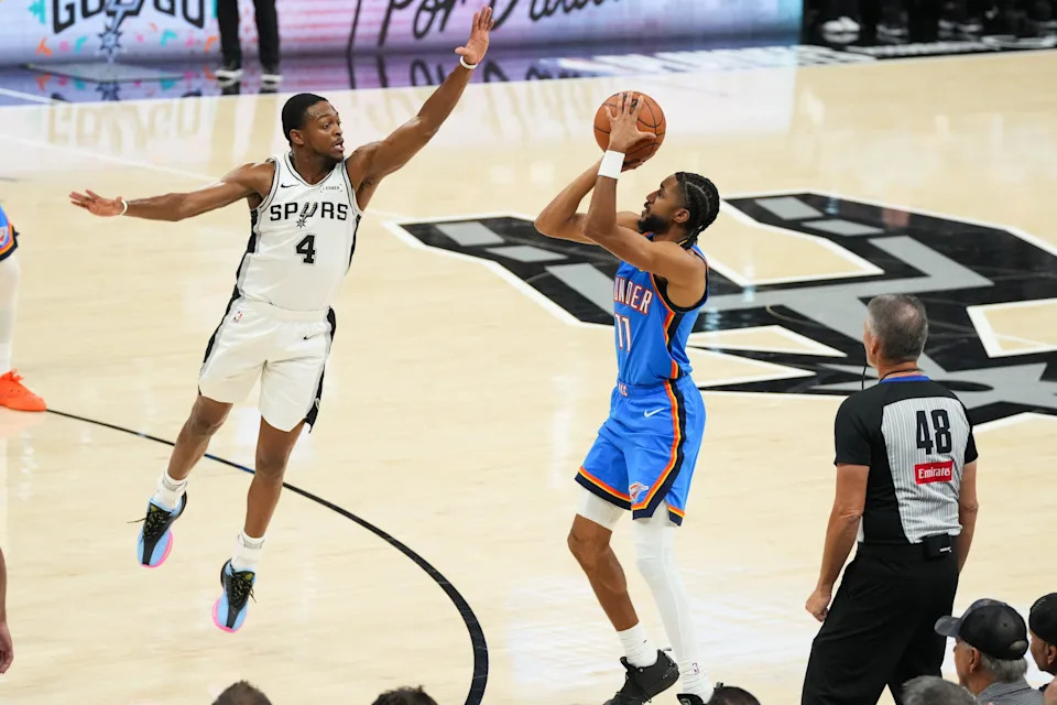 May 24, 2026; San Antonio, Texas, USA; Oklahoma City Thunder guard Isaiah Joe (11) shoots while defended by San Antonio Spurs guard De'Aaron Fox (4) in the first half during game four of the western conference finals for the 2026 NBA playoffs at Frost Bank Center. Mandatory Credit: Scott Wachter-Imagn Images