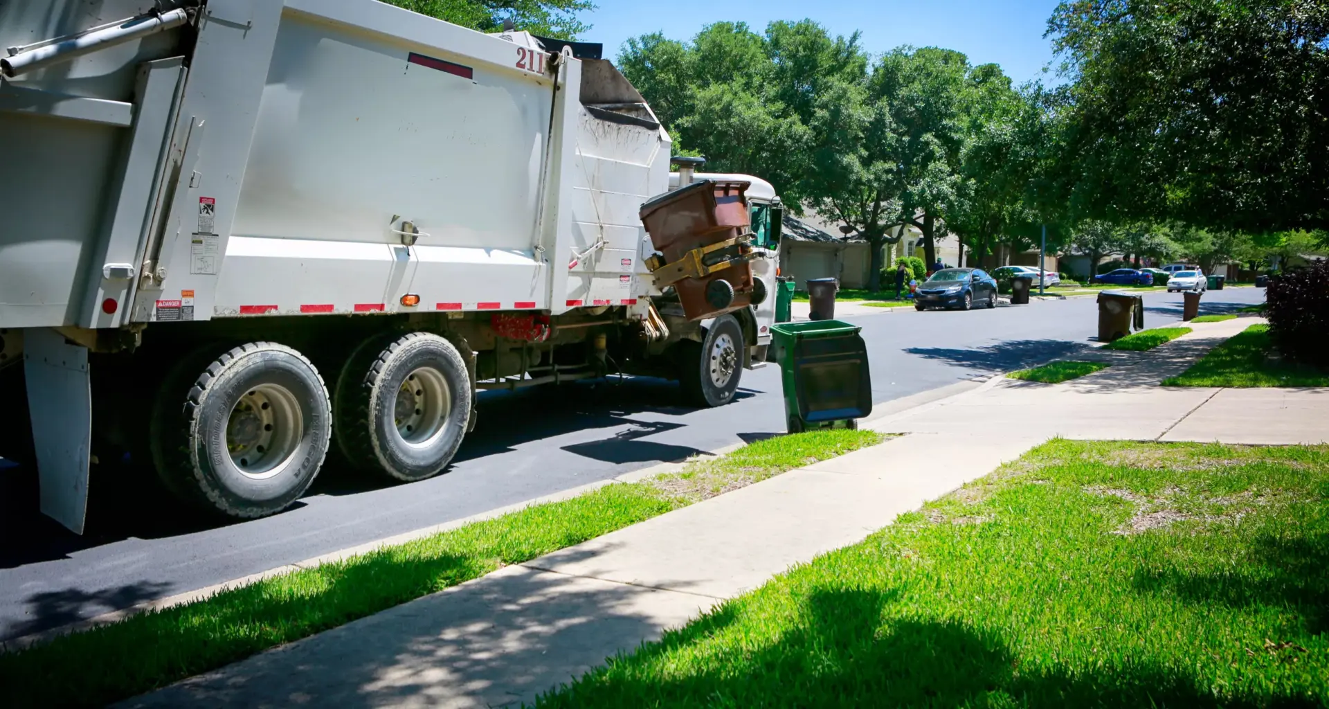 trash truck picking up in a neighborhood