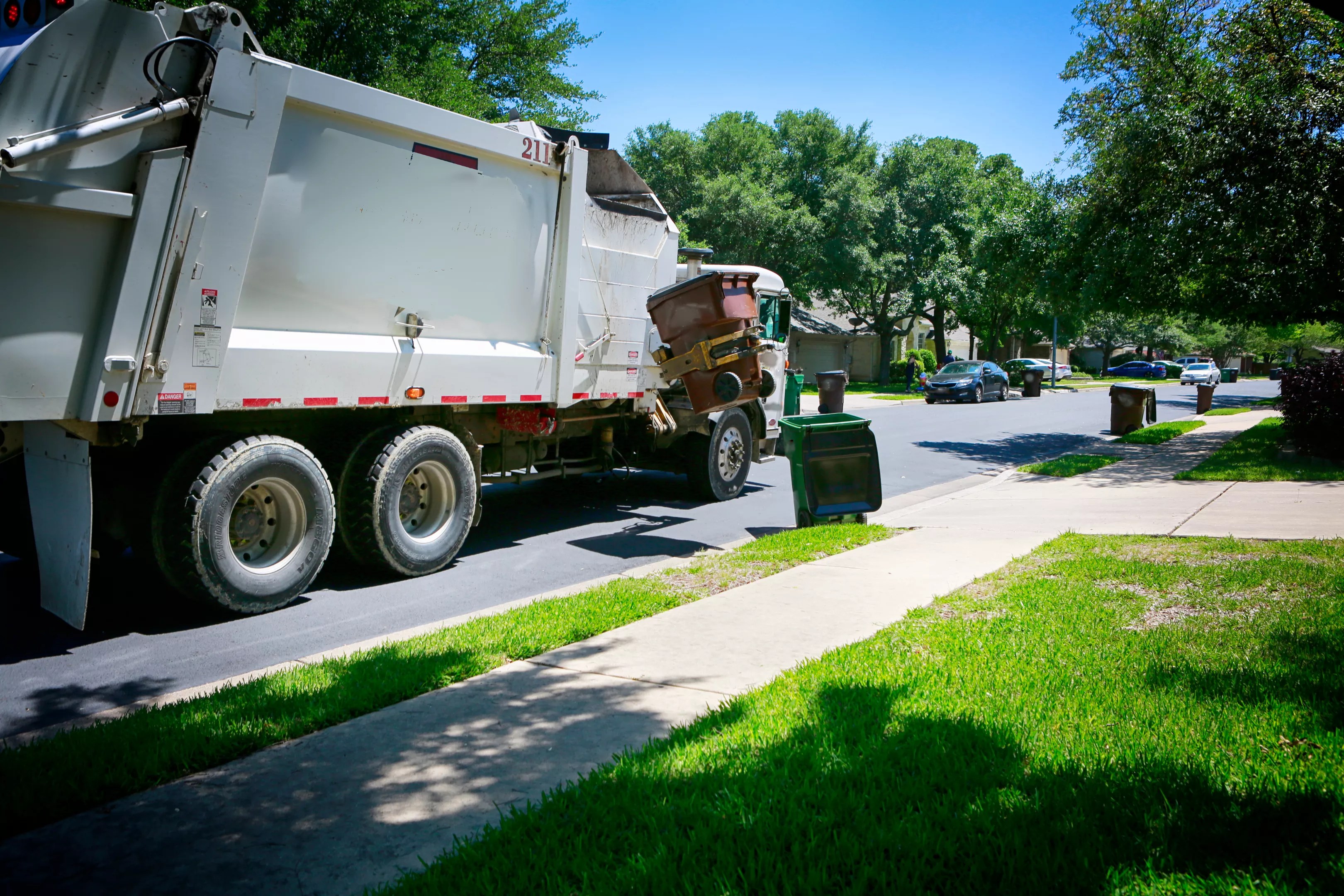 trash truck picking up in a neighborhood